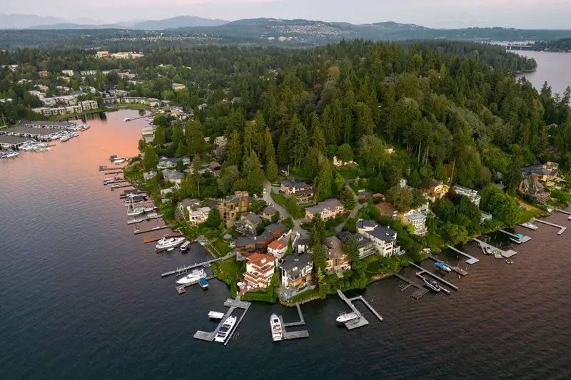 An aerial view at sunset of a wooded shoreline lined with private docks